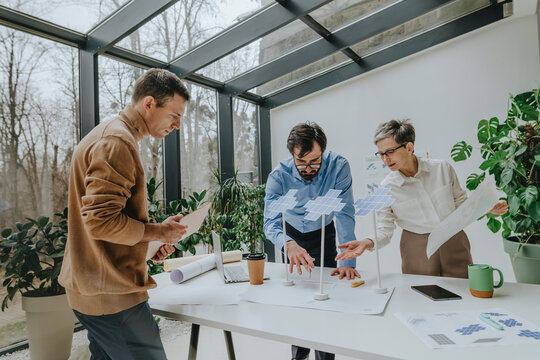 Business people having discussion over solar panels project at desk