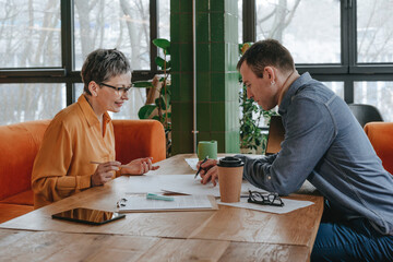Businessman discussing with businesswoman over project in office