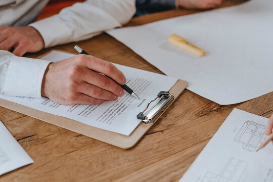 Businessman signing agreement at desk in office