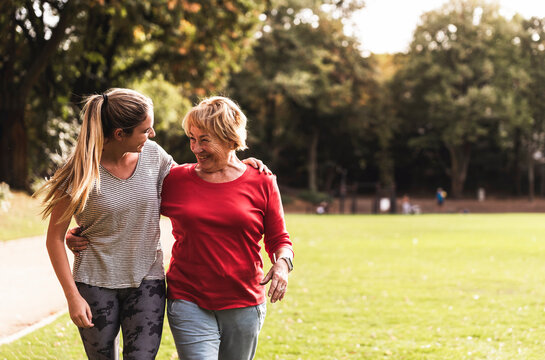 Happy senior woman walking with granddaughter in park