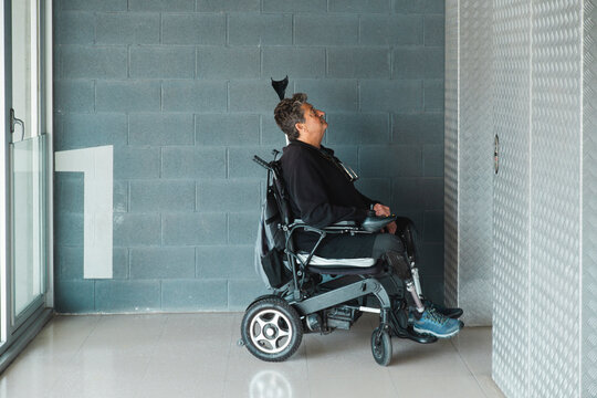 Senior man with disability waiting for elevator in corridor