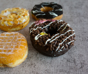 Chocolate and sugar powder donuts on grey background