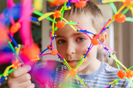 Thoughtful boy playing with expandable breathing ball at home