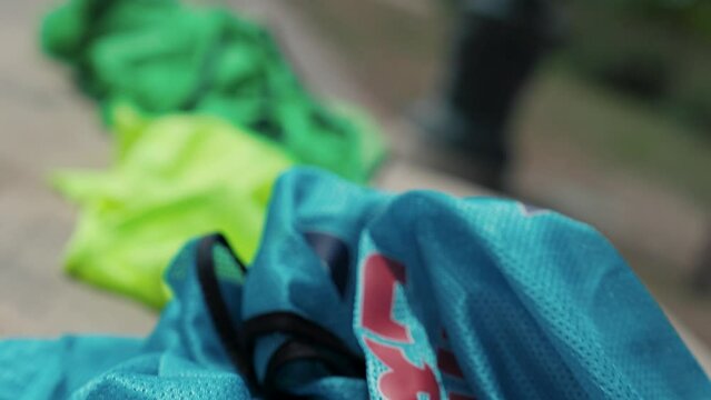 Slow motion revealing shot of various piles of colourful sports bibs