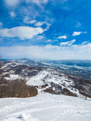 Fototapeta premium Snow resort viewed from the top of a steep slope a sunny day (Madarao Kogen, Nagano, Japan)