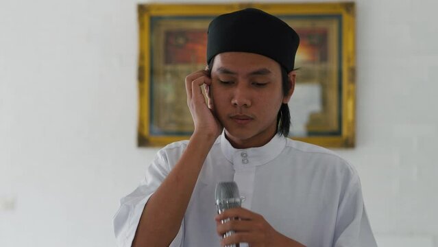 Young Asian Muslim Man Is Doing Adzan From Mosque, A Call For Muslim People To Pray