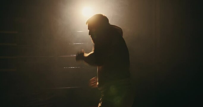 A man trains in a boxing club, a fight with a shadow.