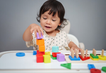 toddler baby playing block toy to stacks building cubes on table