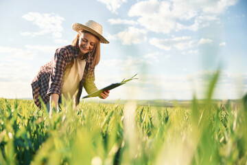 Cheerful facial expression. Young woman is on the beautiful agricultural field at daytime