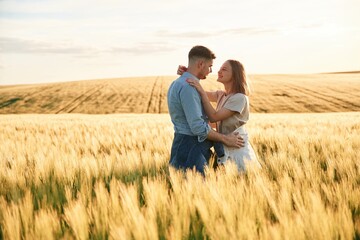 Embracing each other. Lovely beautiful couple are together on the agricultural field