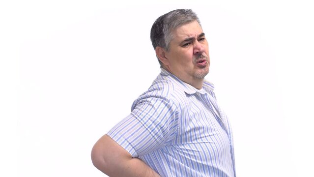 A man winces in pain, holding his lower back. Symptom of osteochondrosis, lordosis, protrusion, intervertebral hernia. White background.