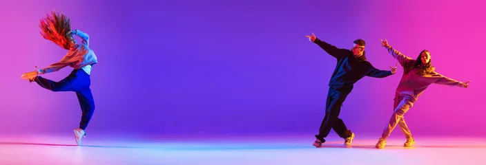 Fotobehang Banner. Young active couple, boys and girls dancing contemp, hip hop against gradient studio background in neon. Concept of contemporary dance style, youth, hobby, action and motion. Ad © Lustre Art Group 