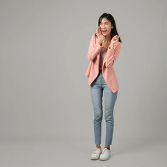 full lenght shoot of happy asian woman shouting with cupping hand and pointing finger wearing formal casual outfit on isolated background