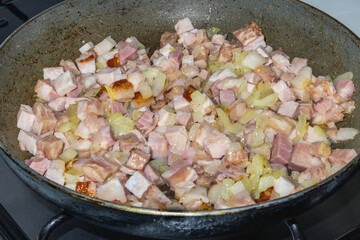 Pork cracklings with onions in a pan