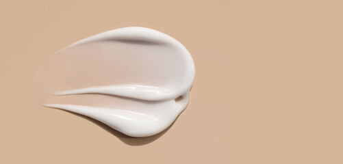 cosmetic smears of creamy texture on a beige background