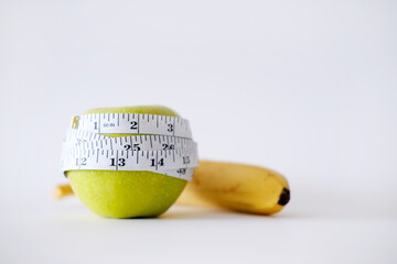 Green apple with white measurement tape