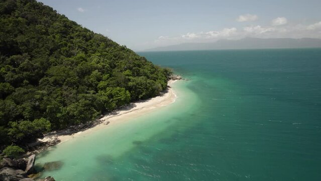 Aerial view of Nudey Beach with turquoise water, lush forest, and mountain, Fitzroy Island, Queensland, Australia.