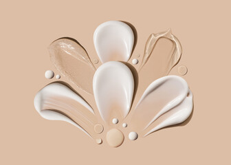 composition of brush strokes of creamy texture of cosmetic samples on a pastel beige background