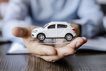 A close-up photo of a toy car in the palm of a man in a business suit. Conceptual photo of a car purchase deal, car diagnostics, car dealership.