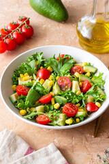 Salad with avocado, tomatoes and corn. Healthy eating. Vegetarian food.