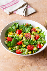 Salad with avocado, tomatoes and corn. Healthy eating. Vegetarian food.