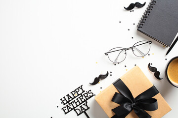 Happy Fathers day concept. Gift box, eyeglasses, a notebook, and a coffee cup on white background. Decorated with Happy Father's Day text and playful elements like stars and mustaches