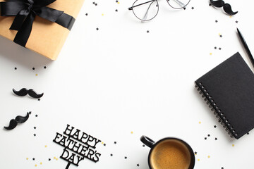 Happy Fathers Day concept. Frame of gift box, coffee cup, glasses, and a notebook. Decorated with star confetti and black mustaches on a white background. Ideal for Father’s Day promotion