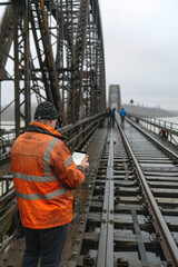 Engineer inspecting structural sensors in bridge, monitoring integrity and safety for public infrastructure.