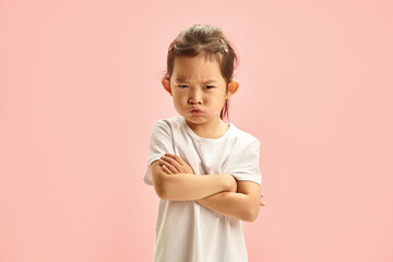 Angry Little Asian Girl Having Gloomy Expression on Face Resentment Looking to Camera Does not...