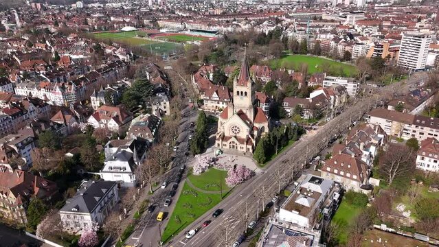 Basel's st. paulus church surrounded by blooming magnolia trees and urban landscape, aerial view