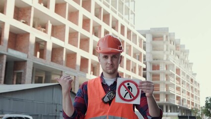 Friendly builder warning people against entering construction site