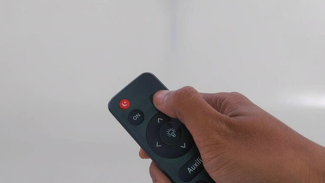 male hand gesture holding and pressing buttons on tv and audio remote control isolated on white background