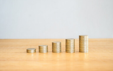 Upward financial growth stack of golden money coin on wooden desk with copy space. Business and financial success concept background. 
