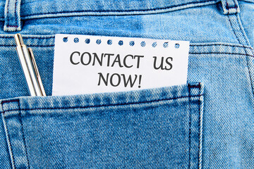 CONTACT US NOW word inscription on a piece of paper that appeared from the pocket of jeans