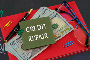 Business, finance and fix your credit here concept. Concept words CREDIT REPAIR on a sticker on the background of a business notebook and dollars