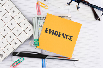 Word EVIDENCE composed on a yellow sticker with money on a business notebook