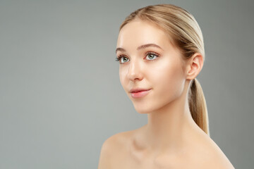 Fototapeta premium Face Skin Care. Teenager Facial Treatment Cosmetology. Beauty Blond Girl Side view Portrait over Gray. Young Woman Smooth clean Skin