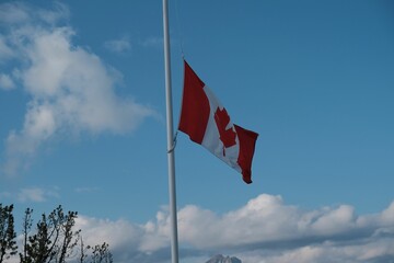 Canadian flag waving against a bright blue sky