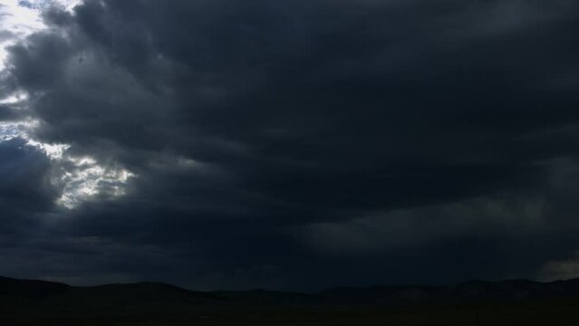 Landscape scene of range hills under dark cloudy sky, for wallpaper