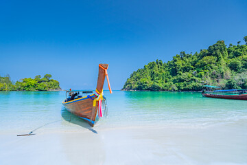 Beautiful sandy beach with long tail boats anchored on the beach of Koh Kamtok, Ranong Province, Thailand, Asia