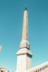 Obelisk stands atop a grand marble staircase, illuminated by natural light