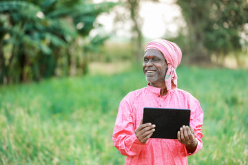 Fototapeta premium Indian farm worker holding tablet