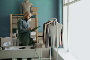 Startup. Small business. The store owner checks the availability of clothes for delivery to the...