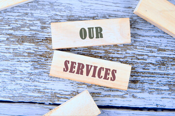 Writing text showing Our Service. Business photo with words OUR SERVICES a conceptual phrase on wooden blocks lying on old boards