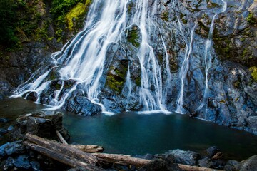 Naklejka premium the waterfall is high in the rocky mountain by a lake