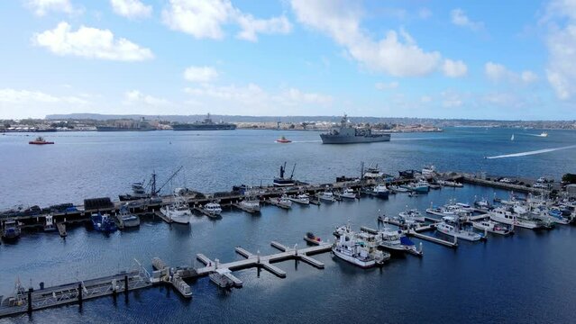 Tuna Harbor and naval ship sailing into port in San Diego, aerial view