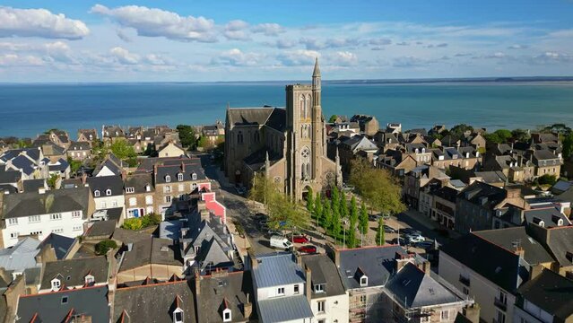Saint-Meen church with sea in background, Cancale, Brittany in France. Aerial drone forward