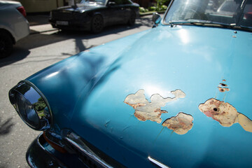  Rusty cracked and peeling paint on an old blue  car.