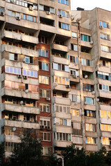 Obraz premium The sunset reflecting in orange, yellow, pink in the many windows of a concrete, socialist, brutalist panel, multi-story, high-rise, apartment block, building, Sofia, Bulgaria