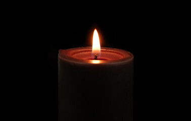 Burning black candle isolated on black background 